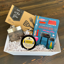 Load image into Gallery viewer, Craft the ideal present with Lit Decor and Gift’s Custom Gift Boxes, featuring a BBQ multi-tool, metal flask, Duke Cannon Bloody Knuckles balm, and “101 Things To Do With A Smoker,” all arranged in white shredded paper.