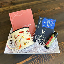 Load image into Gallery viewer, Craft the perfect gift with Lit Decor and Gift’s Custom Gift Boxes, featuring a pink “You and Me Dad” journal, fishing fly enamel mug, multi-tool, lip balm, and shredded filler—beautifully arranged on a wooden surface.